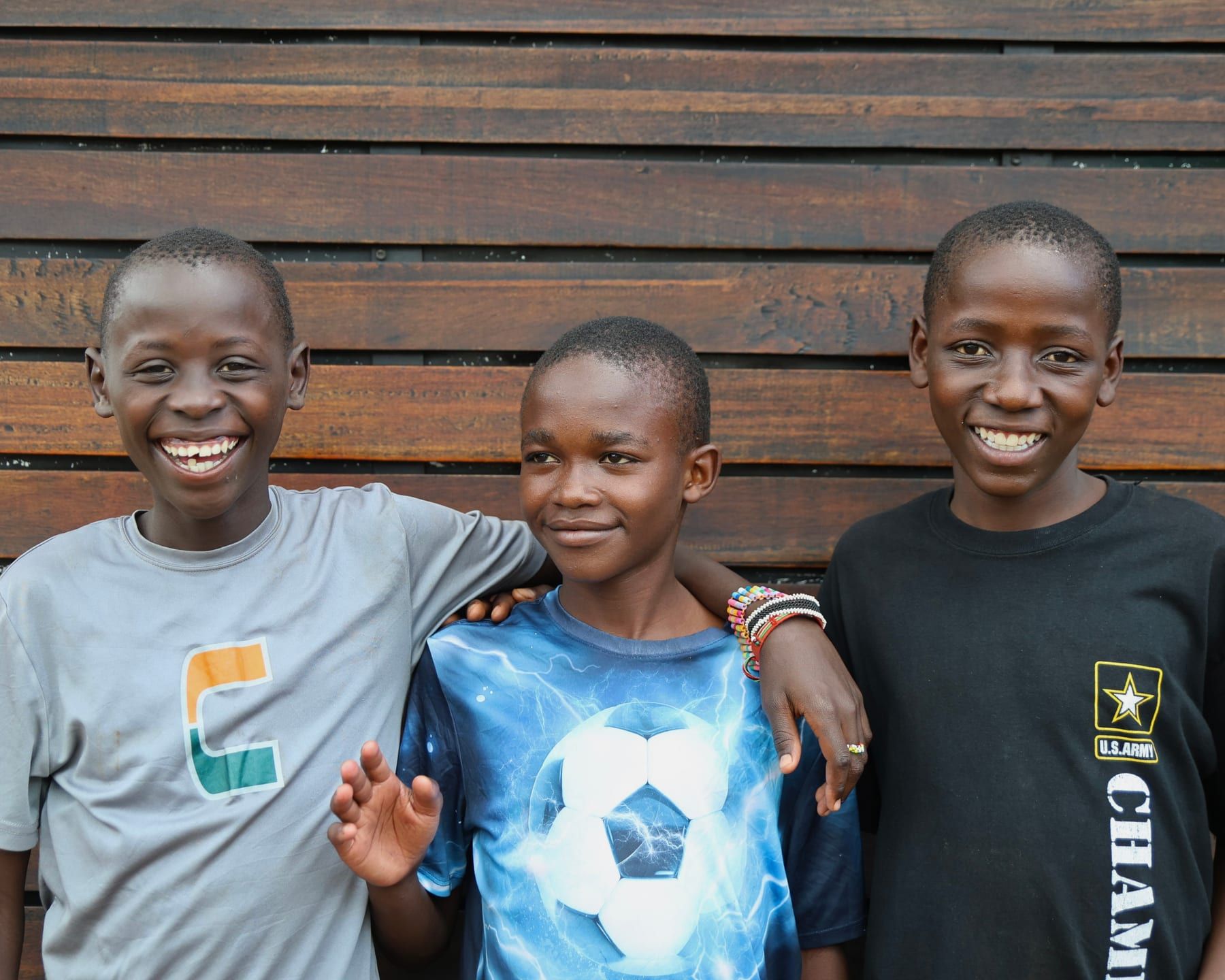 Three boys smiling together at the Embrace Centre