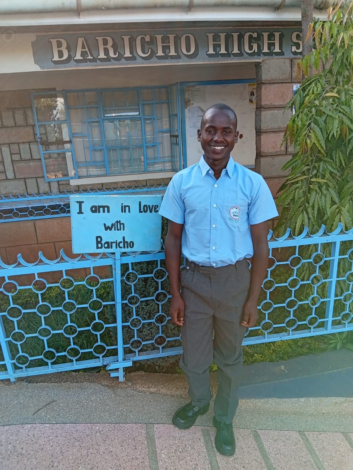 Jackson Mutugi smiling in his school uniform outside Baricho High School