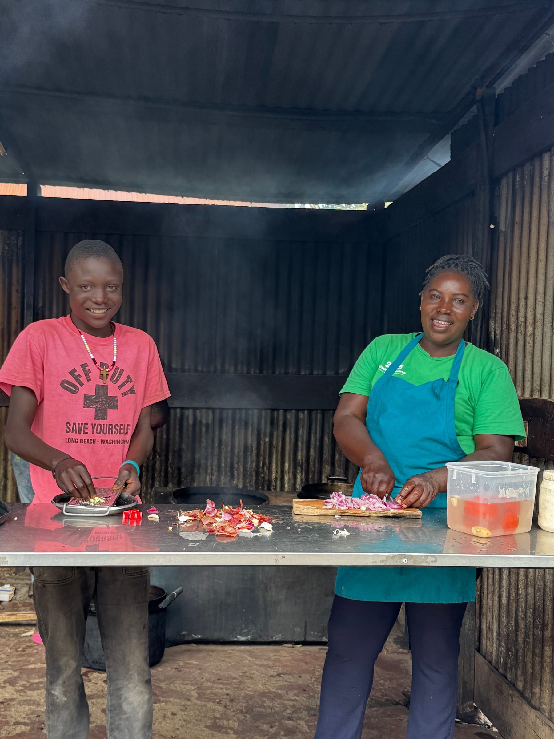 A boy and staff member preparing food as part of daily care at the Kitale Centre