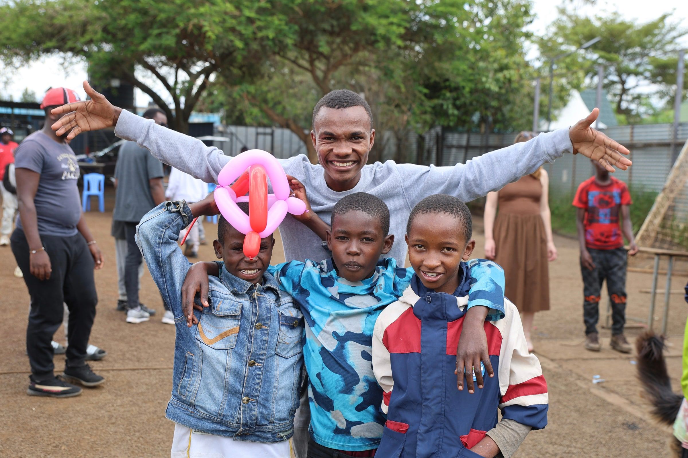 Boys and visiting team members celebrating together during an Embrace Centre activity