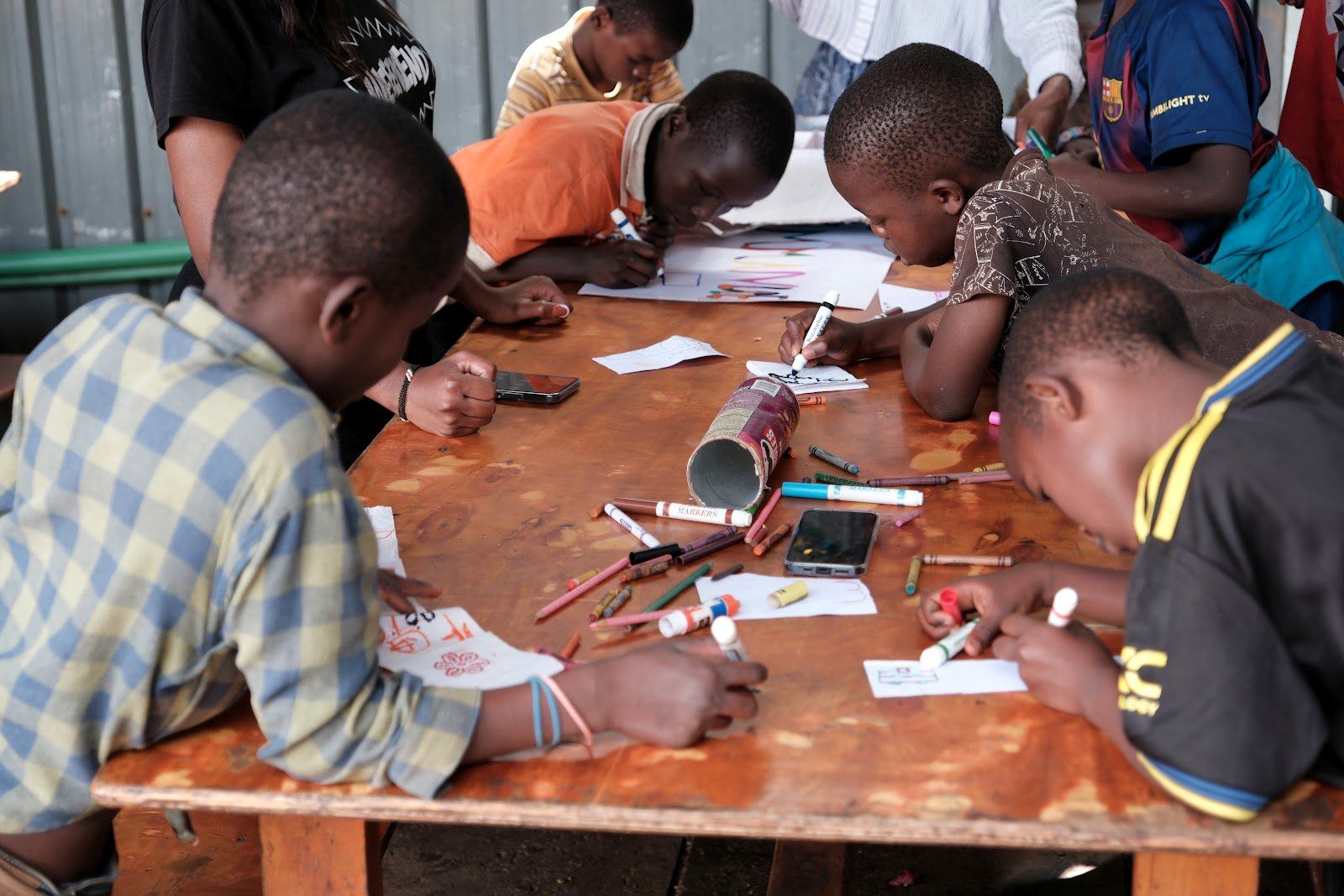 Boys drawing and working on table activities during Embrace Camp