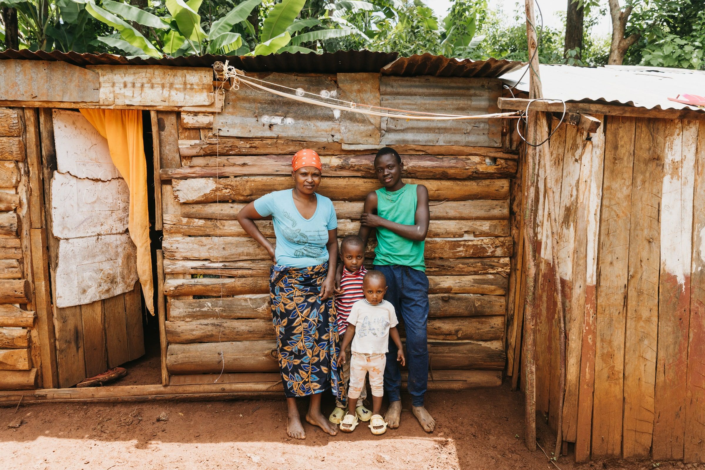 A boy standing with family outside a home during the reintegration journey