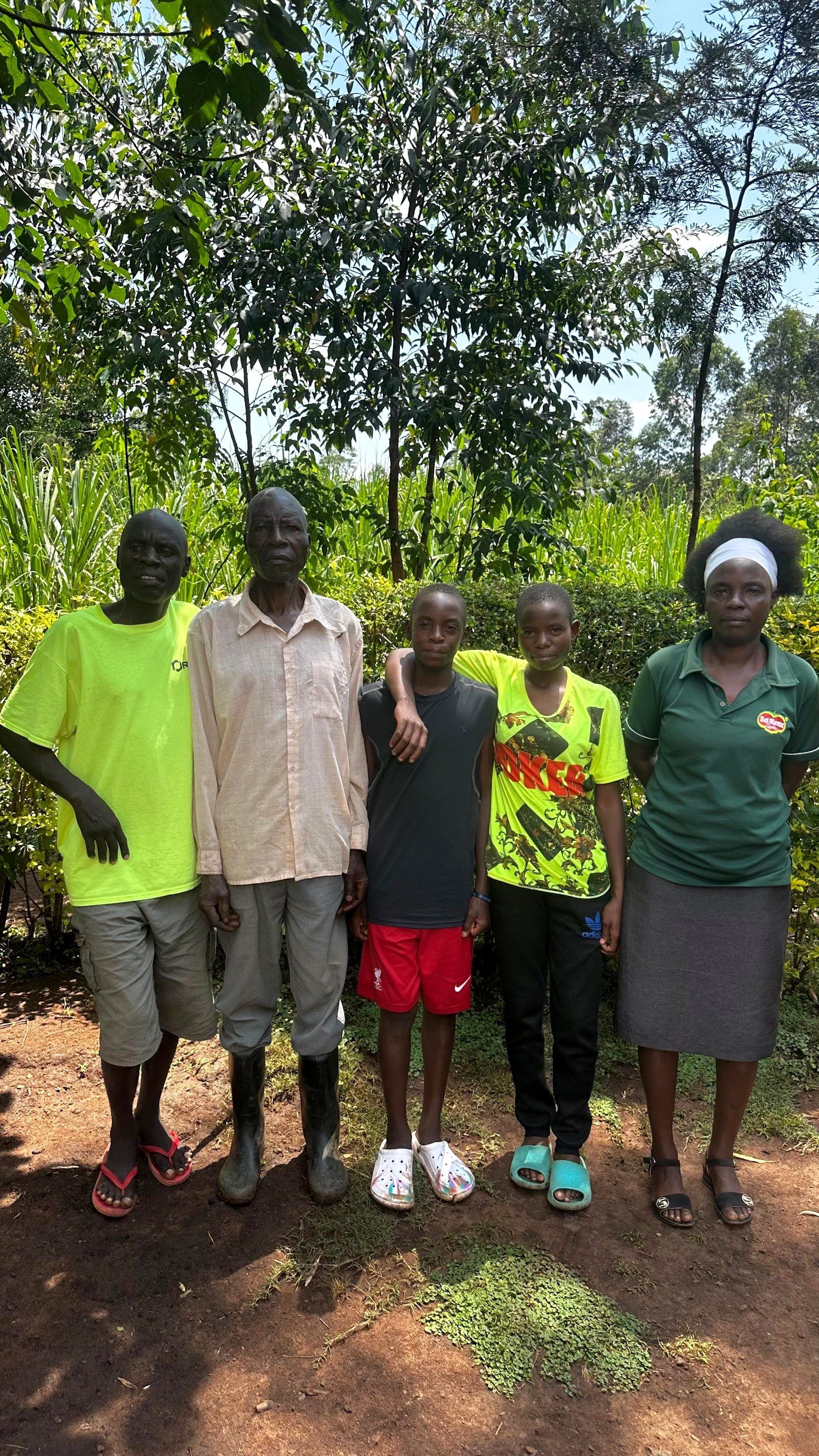 Embrace staff and boys standing together during a family or community follow-up visit in Kenya