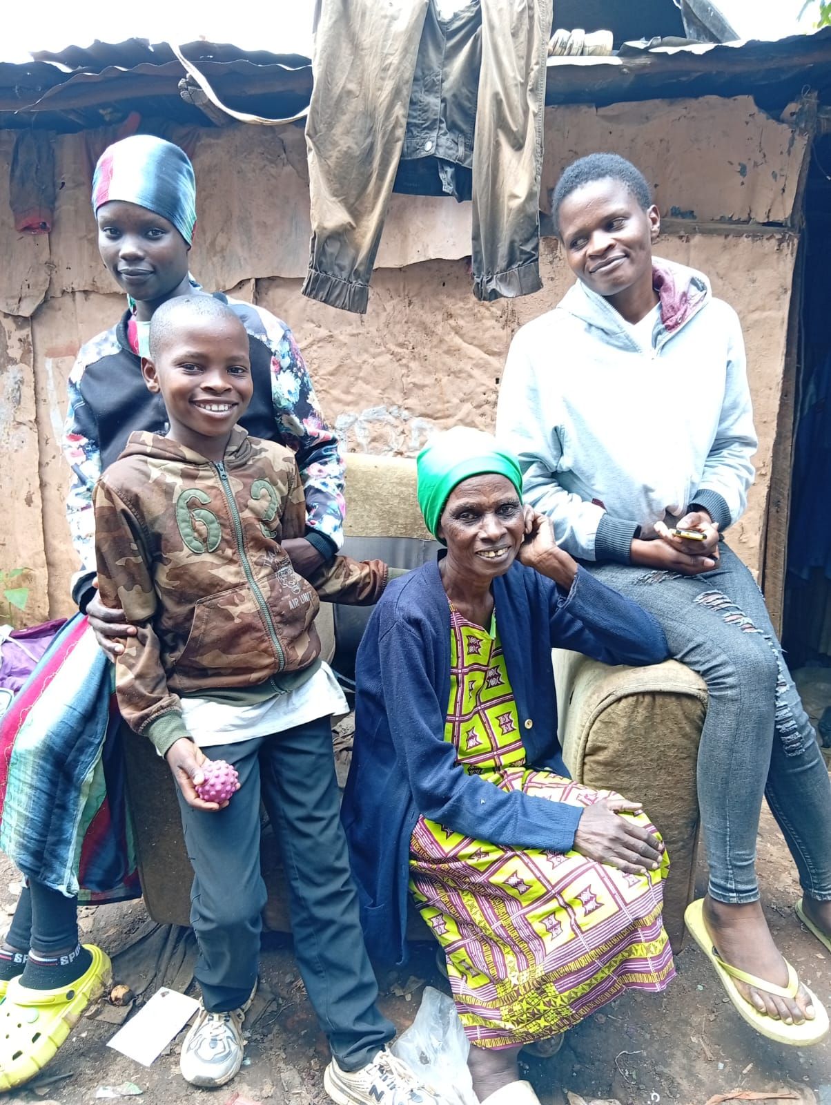 A reintegrated boy standing with family members during a follow-up visit