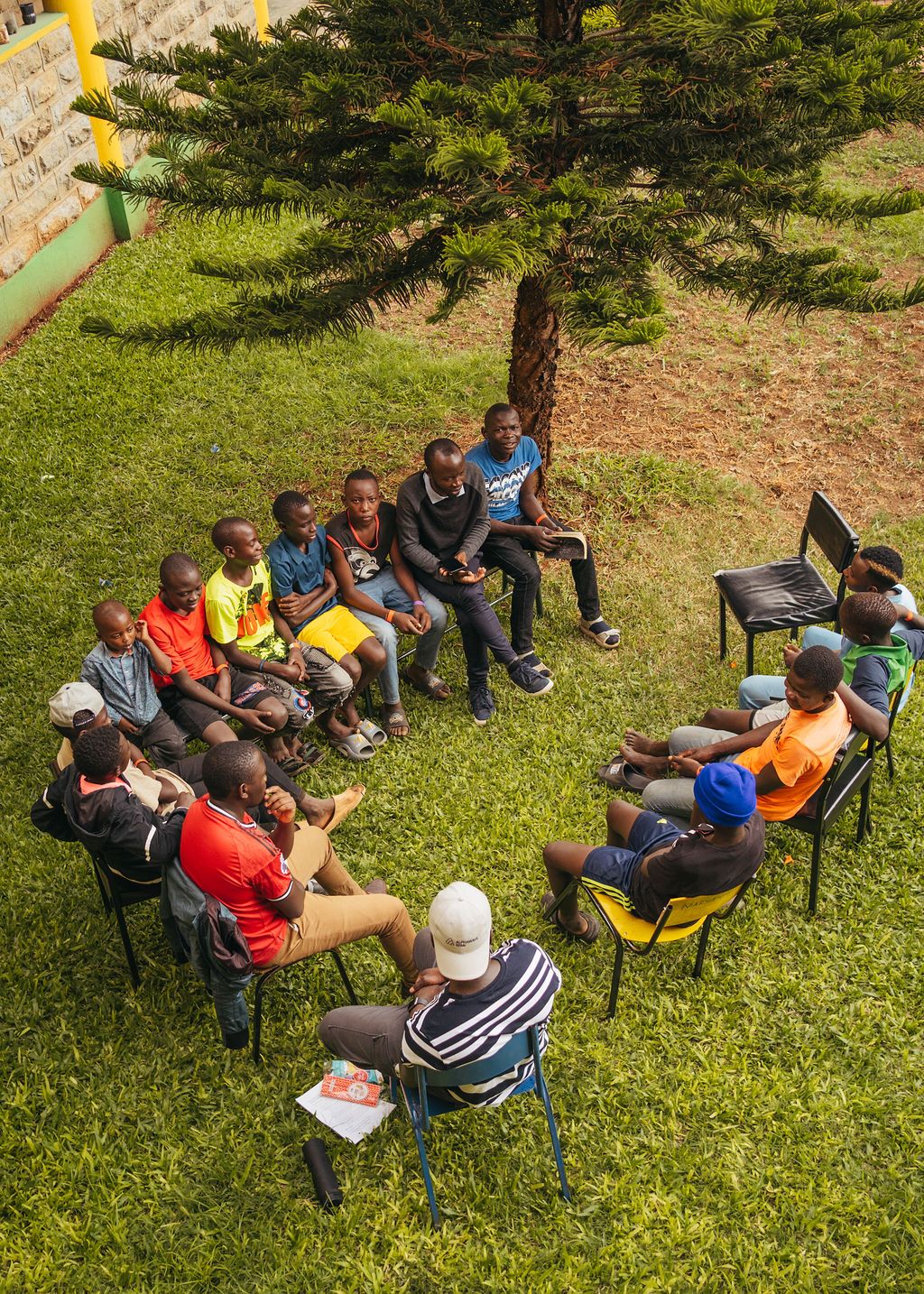 Boys, guardians, staff, and volunteers gathered for a small-group discussion during Reconnect Camp in Kenya