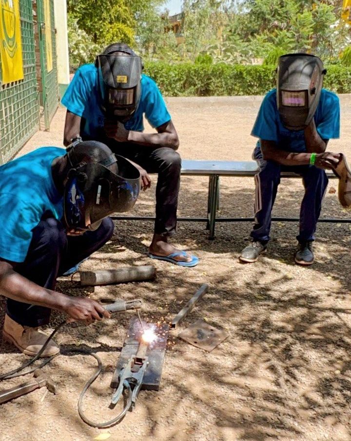 Adults learning welding during a practical Reconnect Camp workshop