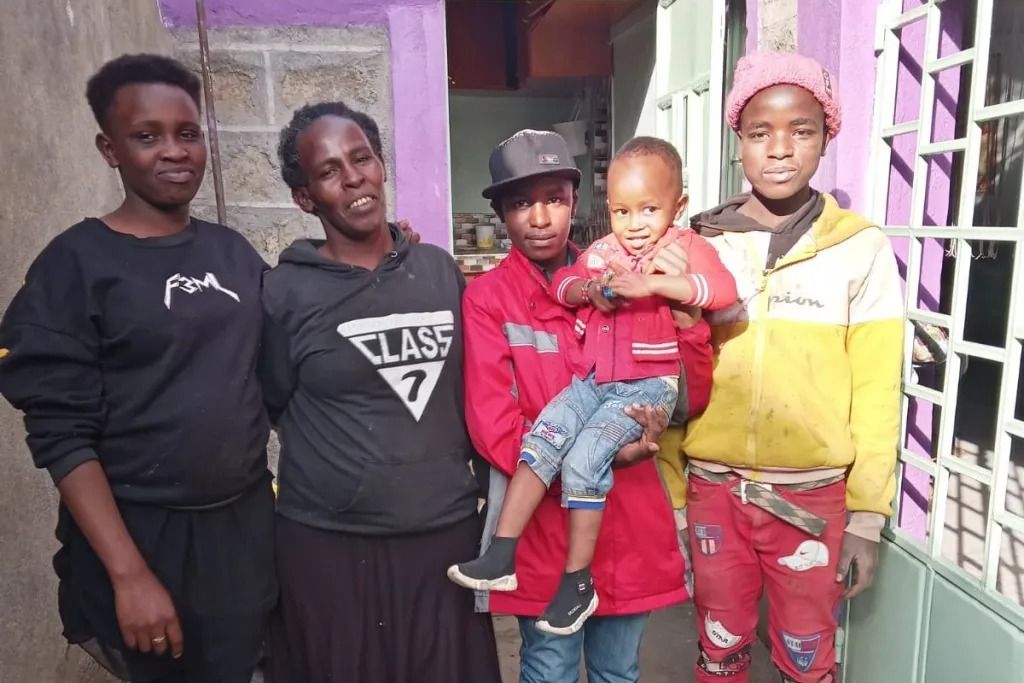 A reunited family standing together at home